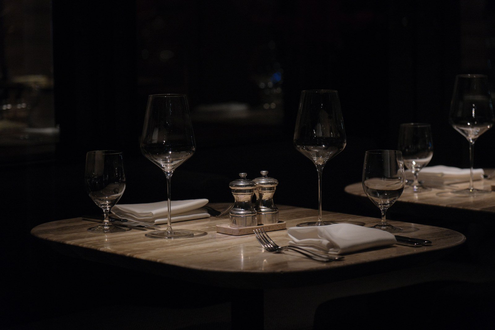 Dining — a table set for two, crystal, low light.