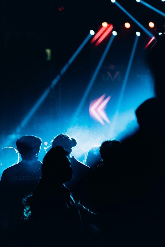 A night crowd under blue stage light.