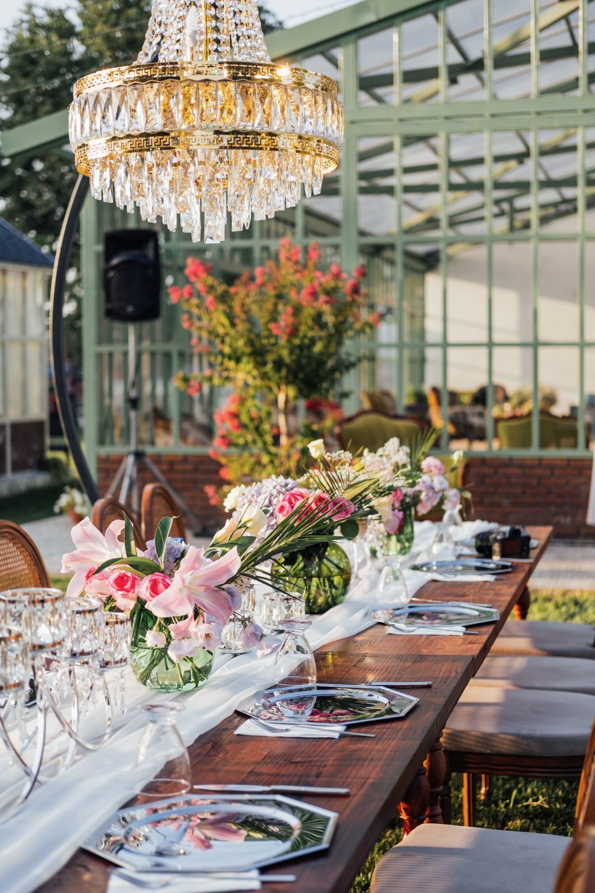 The Hamptons — an outdoor table under a chandelier.